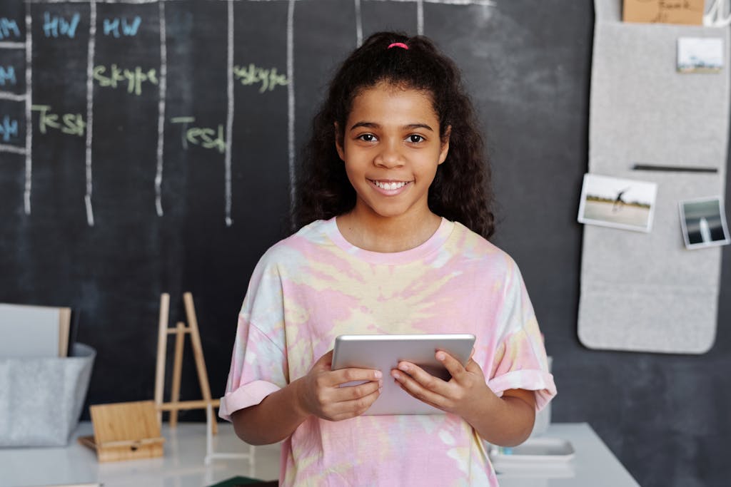 Woman in Pink Crew Neck T-shirt Holding Tablet Computer